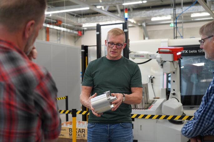 Aufnahme von Lennart Lange bei der Vorstellung eines produzierten Werkstücks in der Fertigung in Schönkirchen