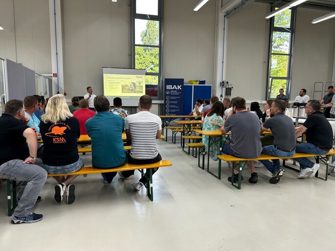 Teilnehmer des "Workshops on the road 2024" hören dem Vortrag von Dennis Marczinski zu