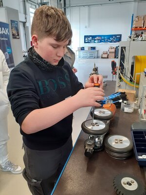 Ein Auszubildender beim Radwechsel am Fahrwagen T66