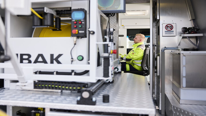 Aufnahme eines Bedieners am Bediensystem vom Fahrzeugheck aus